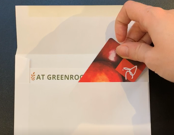 Grocery gift card being packed into envelope