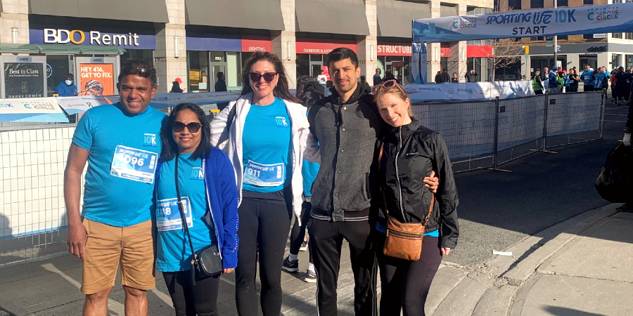 Greenrock team posing in front of Sporting Life 10K starting line